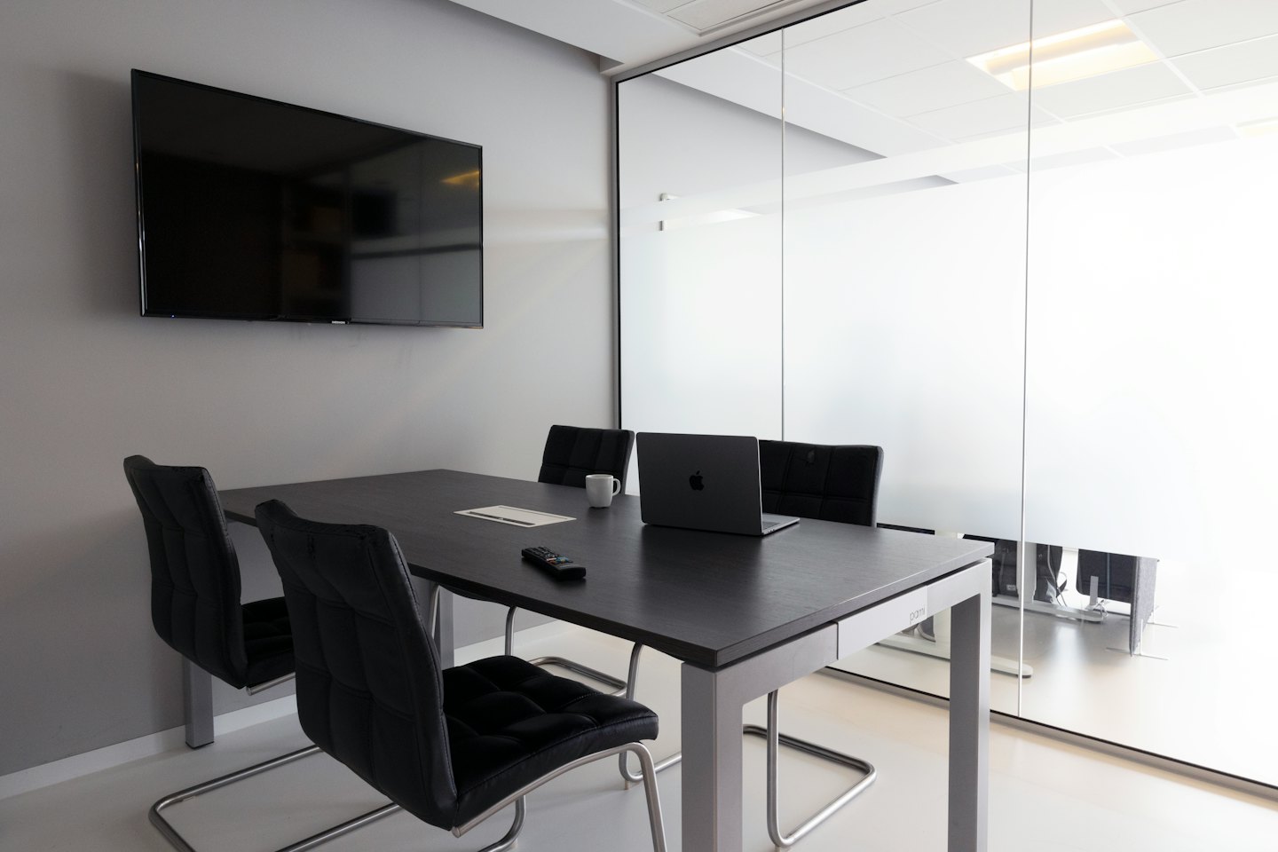 Sala de reuniones corporativa moderna con mesa y sillas.